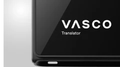 Close-up of a black Vasco Translator device displaying the white Vasco logo and “Translator” text on its screen.