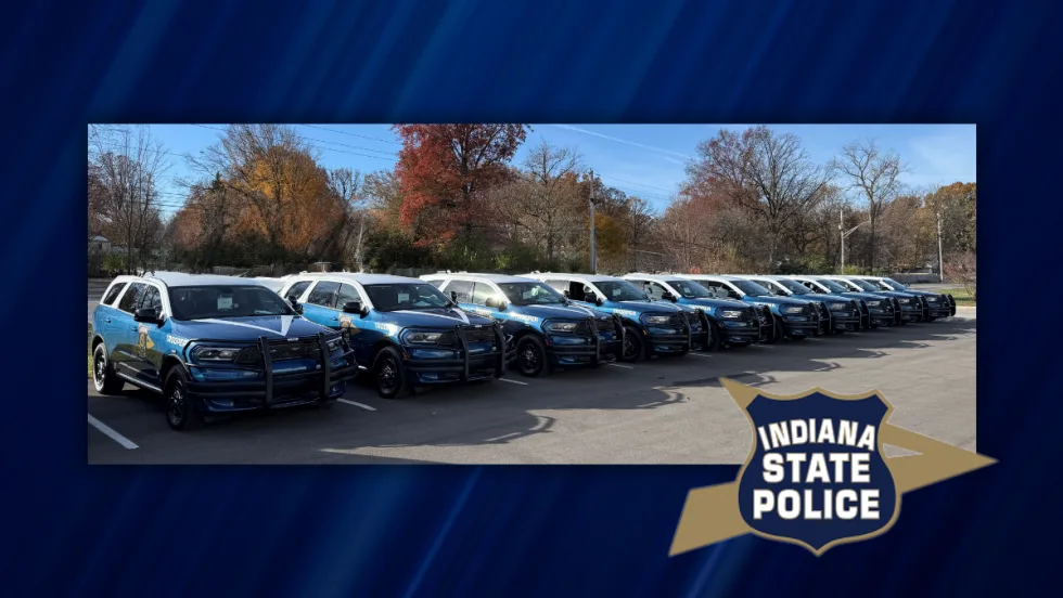 Row of newly designed Indiana State Police Dodge Durango patrol vehicles parked outdoors, marking the rollout of the new fleet design for graduating troopers.