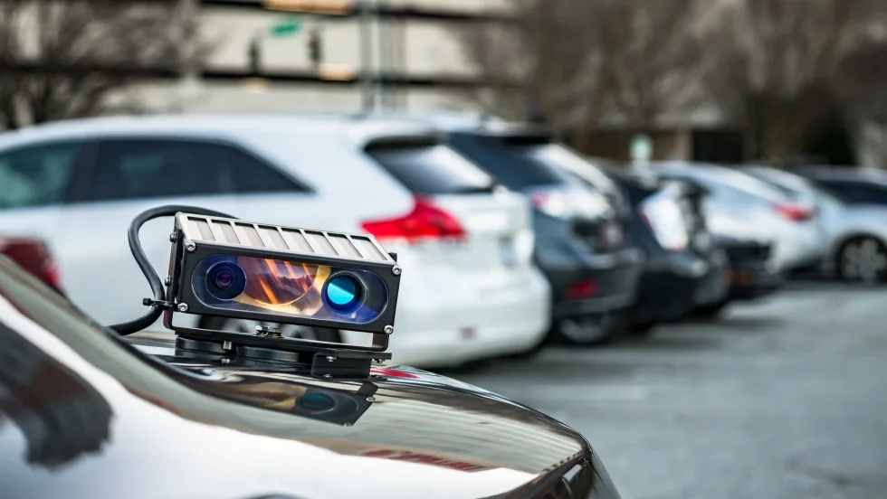 An automated license plate reader mounted on rear trunk of a car.