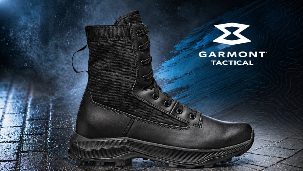 Black military style boot in leather against a blue and black cobblestone surface and a white logo for Garmont Tactical in upper right.
