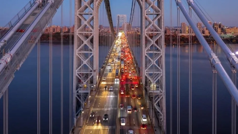 High-angle view of cars with lights turned on crossing the George Washington Bridge at dusk.