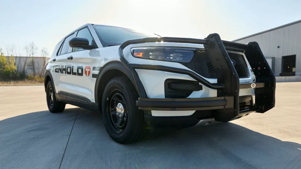 Low-angle front-corner image of a police car with push bumper.
