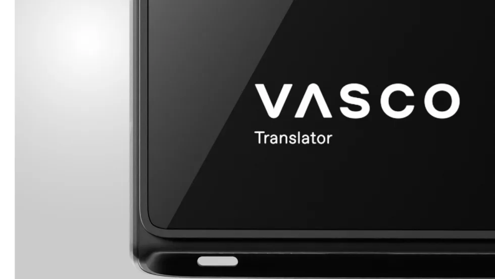 Close-up of a black Vasco Translator device displaying the white Vasco logo and “Translator” text on its screen.
