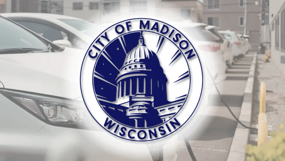 City of Madison, Wisconsin seal overlaid on an image of electric vehicles parked and charging in a row.