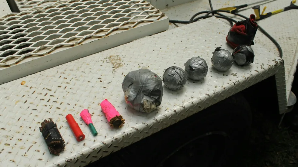 Assorted metal objects, electrical components, and colored tubes on industrial surface
