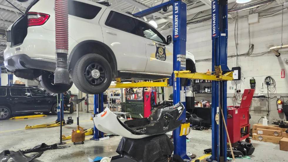 A white Dodge Durango Pursuit is pictured on a blue Rotary lift.