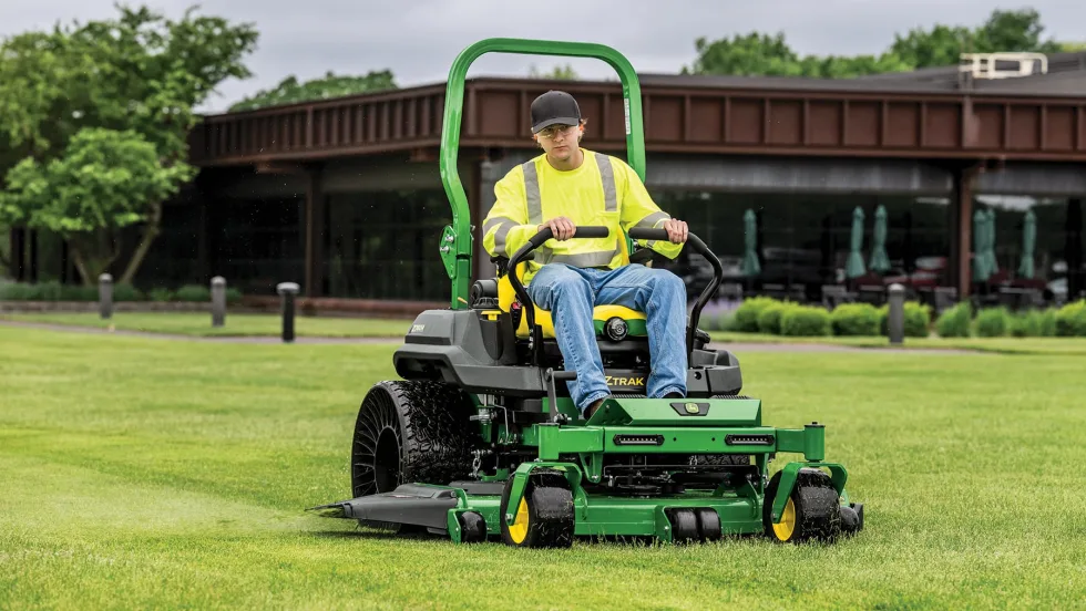 Man on John Deere cutting the Lawn