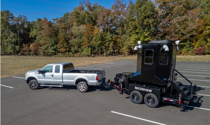 mobile observation tower being towed behind a silver pickup truck