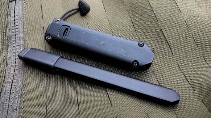 Two slim black Streamlight flashlights, the Wedge SL and Wedge XT, rest side by side on an olive tactical fabric surface, highlighting their compact designs and USB-C charging capability on the XT.