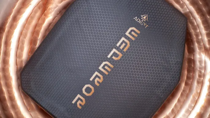 Close-up of an Adept Armor Emperor protective plate featuring a dark hexagonal-textured surface and prominent Emperor branding, displayed against a metallic copper-colored background.