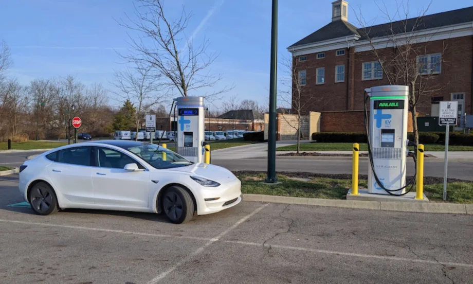 An electric vehicle charges at a public EV charging station outside a municipal building.