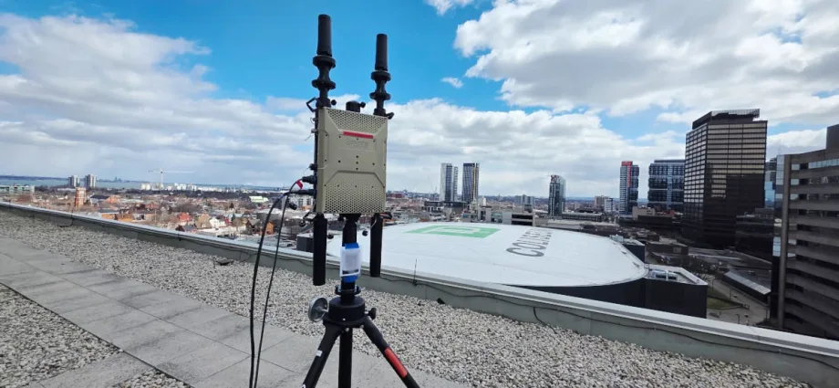 Rooftop view off a drone detection devise with two small rubber antennas with an view overlooking a large domed event venue.