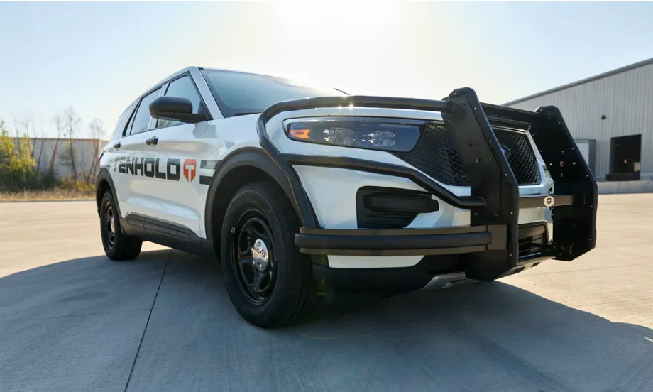 Low-angle front-corner image of a police car with push bumper.