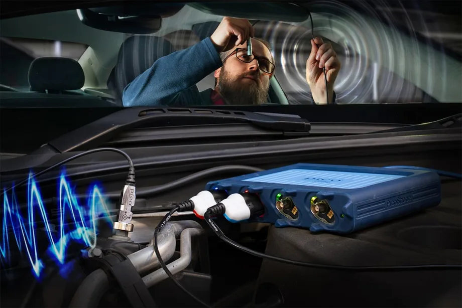 Technician using PicoScope NVH diagnostic device inside a vehicle, connecting sensors to measure vibration and noise from engine components.