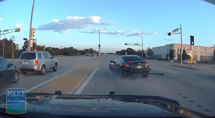 Police dashcam view of intersection with traffic and vehicles