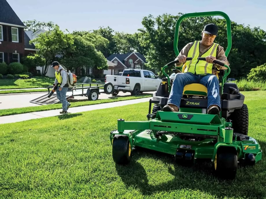 Man on John Deere cutting the Lawn