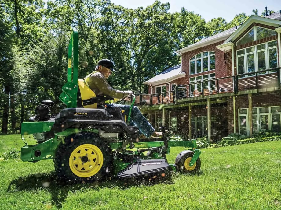 Man on John Deere cutting the Lawn